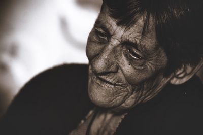 Close-up of senior woman looking away while standing outdoors