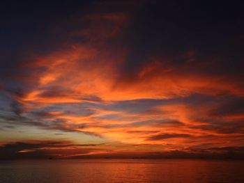 Scenic view of sea against dramatic sky during sunset