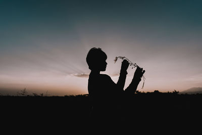 Silhouette man standing against sky during sunset