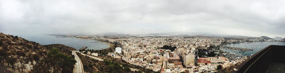 High angle view of town by sea against sky