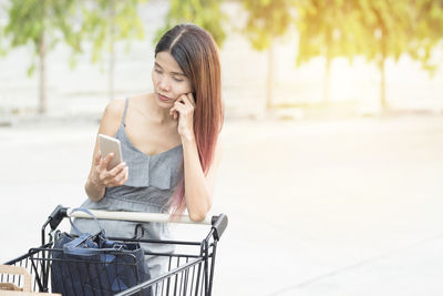 Young woman using mobile phone outdoors