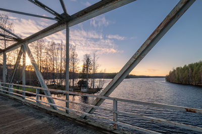 Bridge over river against sky during sunset