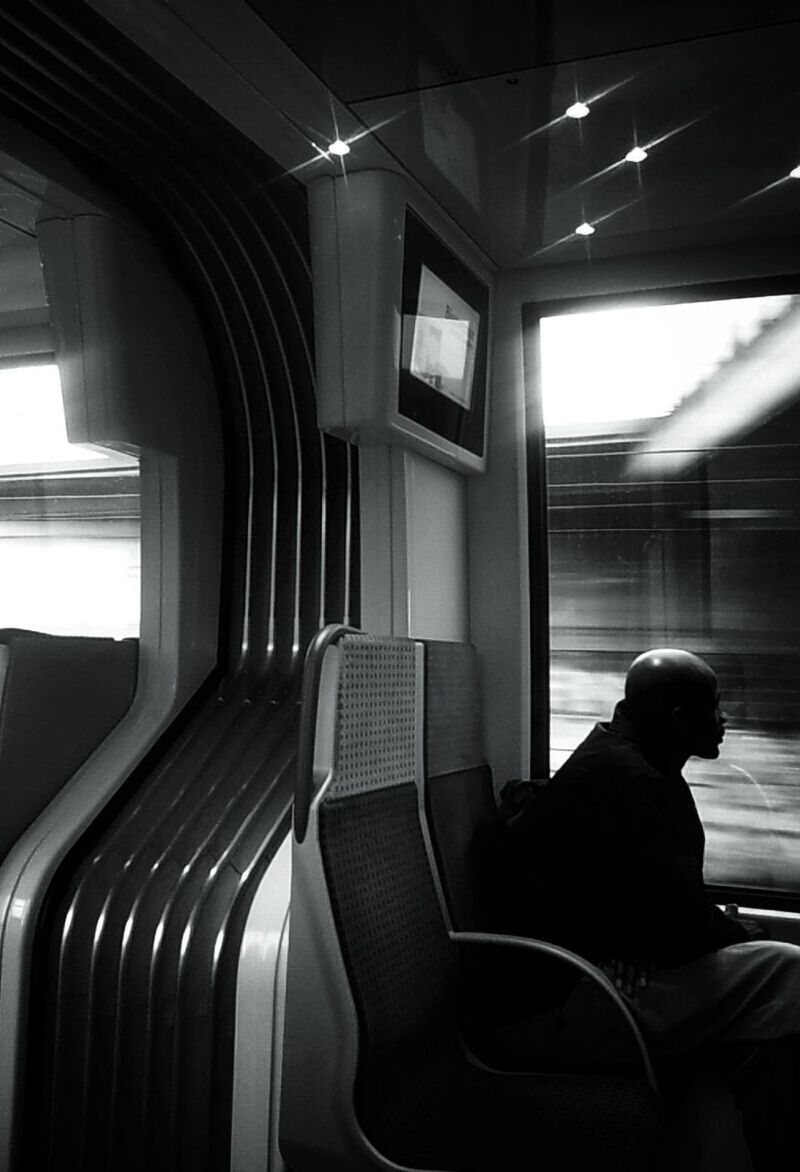 indoors, window, sitting, vehicle interior, chair, rear view, transportation, lifestyles, vehicle seat, seat, men, travel, person, mode of transport, relaxation, glass - material, leisure activity, interior