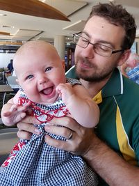 Father holding cute daughter at restaurant