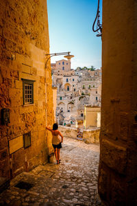 Rear view of woman and matera buildings