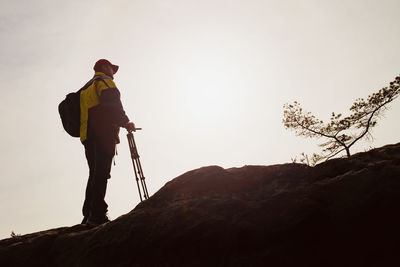 Photographer with tripod in heavy mist in morning in rocky park. view into valley