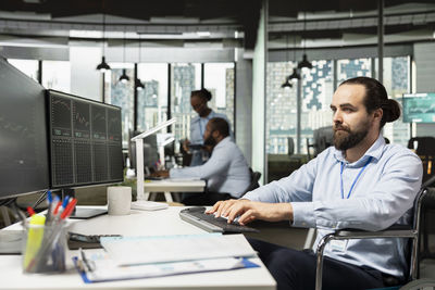 Man using laptop at desk in office