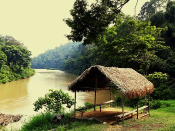 Gazebo by lake against trees