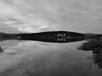 Reflection of building in lake against sky