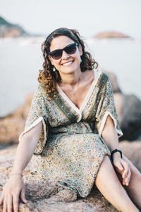 Portrait of a smiling young woman sitting on beach