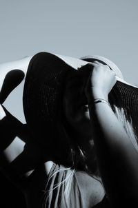 Close-up portrait of woman wearing hat against sky