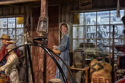 Portrait of man with bicycle standing by window