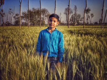 Portrait of smiling young woman standing on field