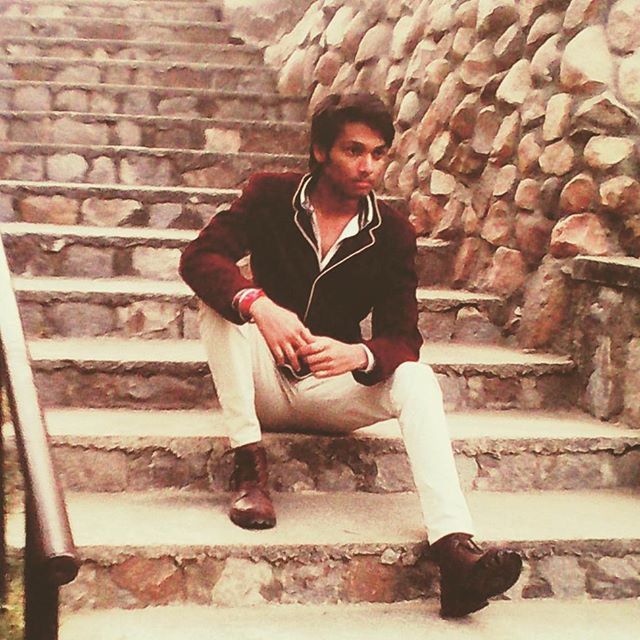 FULL LENGTH PORTRAIT OF YOUNG MAN STANDING ON WALL