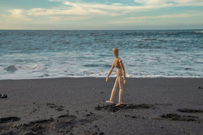 View of shirtless boy on beach against sky