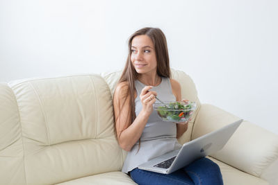 Portrait of woman sitting on sofa at home