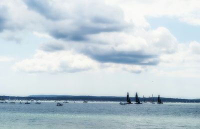 Boat sailing in sea against cloudy sky