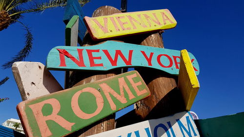 Low angle view of information sign against clear blue sky