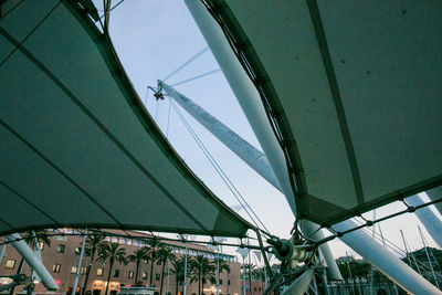 Low angle view of amusement park in city against sky