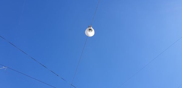 Low angle view of electric light against blue sky