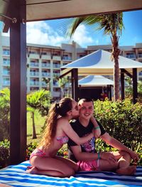 Woman kissing man while sitting in gazebo