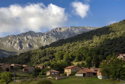 Houses by mountains against sky