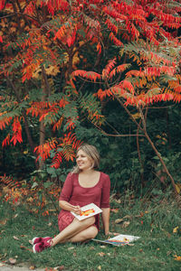 Full length of a beautiful woman holding red flowers