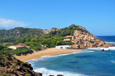 Scenic view of sea and mountains against clear blue sky