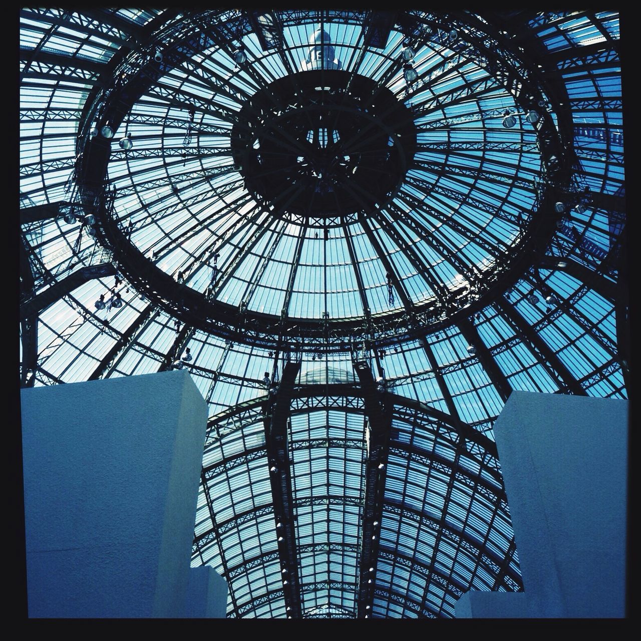 indoors, low angle view, built structure, architecture, transfer print, ceiling, pattern, auto post production filter, glass - material, geometric shape, directly below, day, design, skylight, circle, silhouette, clock, modern, window, architectural feature