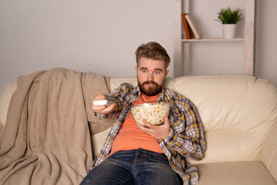 Portrait of man sitting on sofa at home