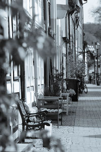 Empty benches by building on sidewalk