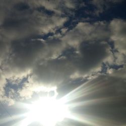 Low angle view of sun shining in sky