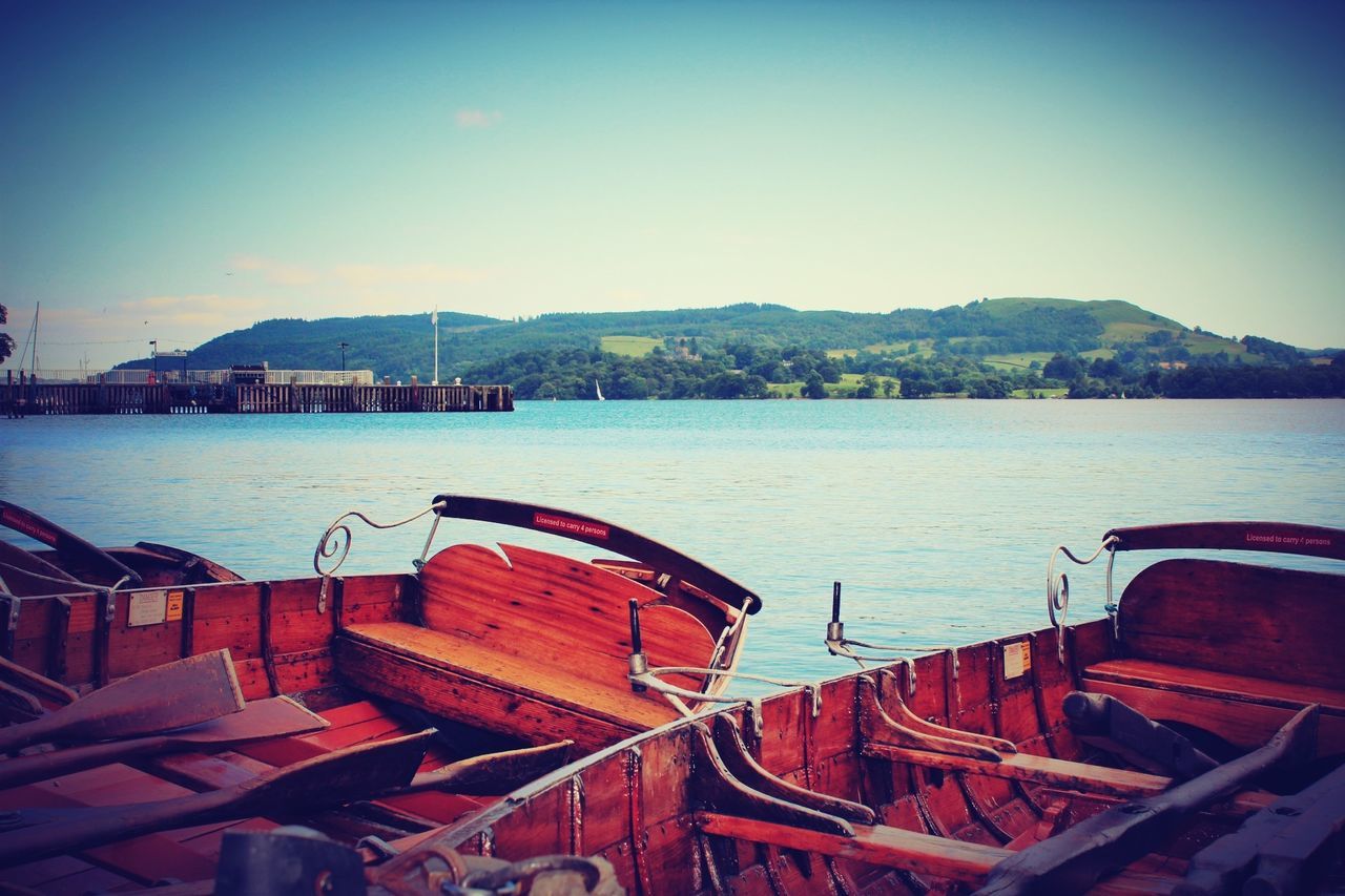 water, sea, nautical vessel, clear sky, boat, moored, transportation, mountain, sky, built structure, pier, tranquility, mode of transport, copy space, lake, tranquil scene, blue, nature, river, harbor