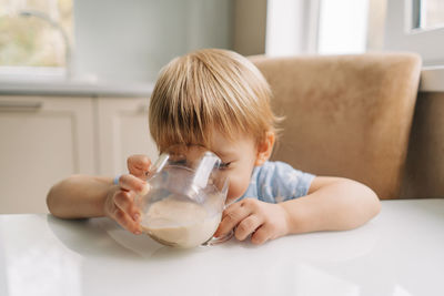 Cute girl drinking milk at home