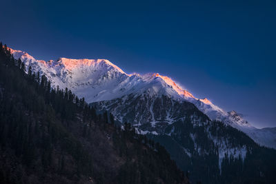 White snow mountain with blue sky, peak of the mountain at the evening time. 