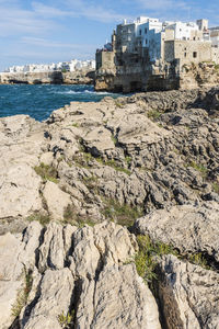 Scenic view of sea by buildings against sky