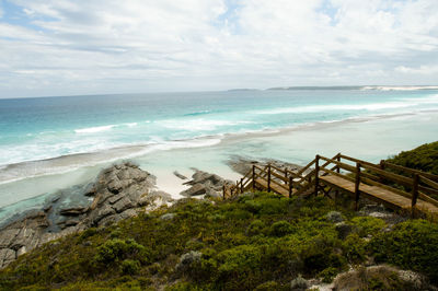 High angle view of steps and beach against cloudy sky