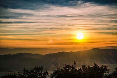 Scenic view of silhouette mountains against orange sky