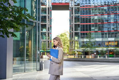 Portrait of young woman standing in city