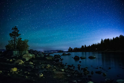 Scenic view of lake against sky at night