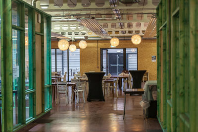 Empty chairs and tables in illuminated building