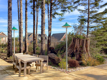 Trees by built structure against sky