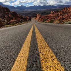 Road by desert against sky