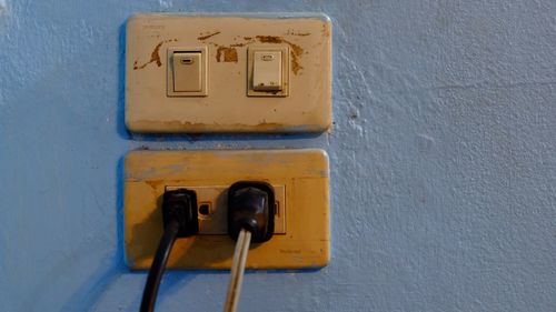 Close-up of telephone booth against wall