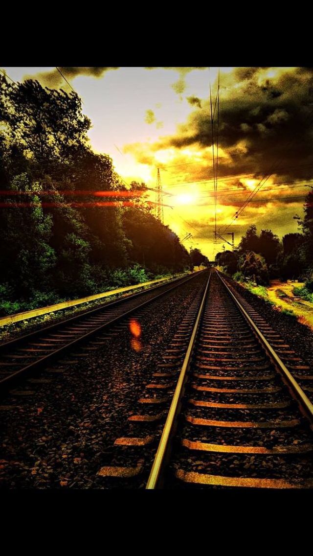 VIEW OF RAILWAY TRACKS AGAINST SKY AT SUNSET