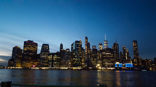 Illuminated buildings in city against sky