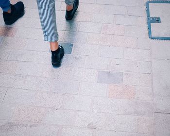 Low section of woman standing on tiled floor