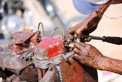 Close-up of man working on bicycle