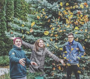 Portrait of young couple standing against plants