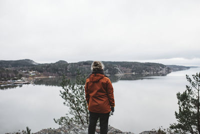 Rear view of man looking at mountains against sky